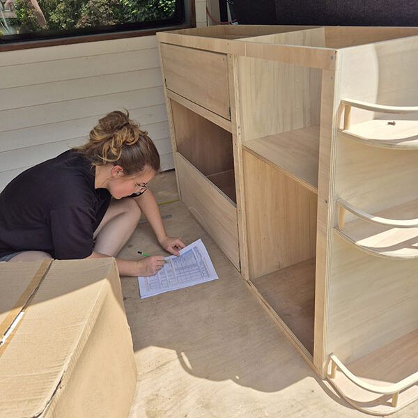 Ébéniste Cosy Van à Strasbourg en pleine conception d’un meuble de cuisine sur mesure dans un Peugeot Boxer, ajusté aux dimensions du véhicule pour un aménagement bois personnalisé.