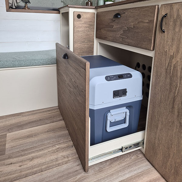 Cuisine sur mesure installée par Cosy Van avec meuble en bois et glacière à compression, exemple d’équipement essentiel pour un van aménagé type Renault Trafic, Boxer, Transporteur T6 ou autre.