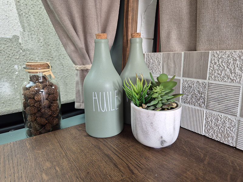 Détail déco dans un van aménagé par Cosy Van : petit pot de fleurs posé sur un plan de travail en chêne massif dans une cuisine sur mesure, pour une ambiance chaleureuse et personnalisée.